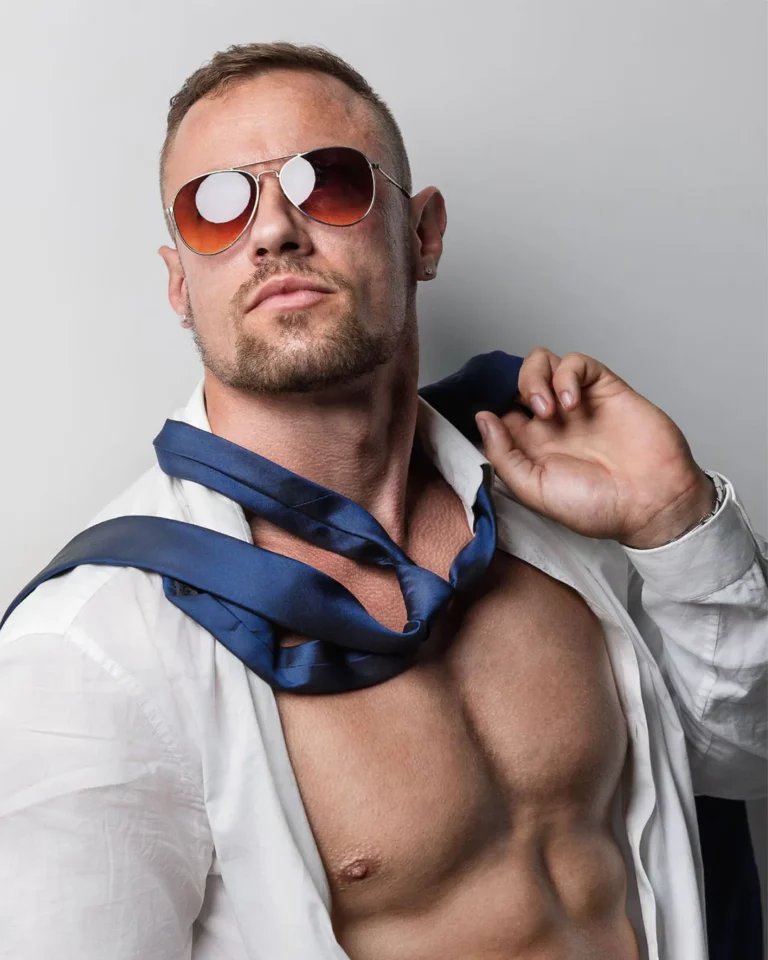 Drogo, artiste Golden Boys, en chemise blanche décontractée et lunettes de soleil