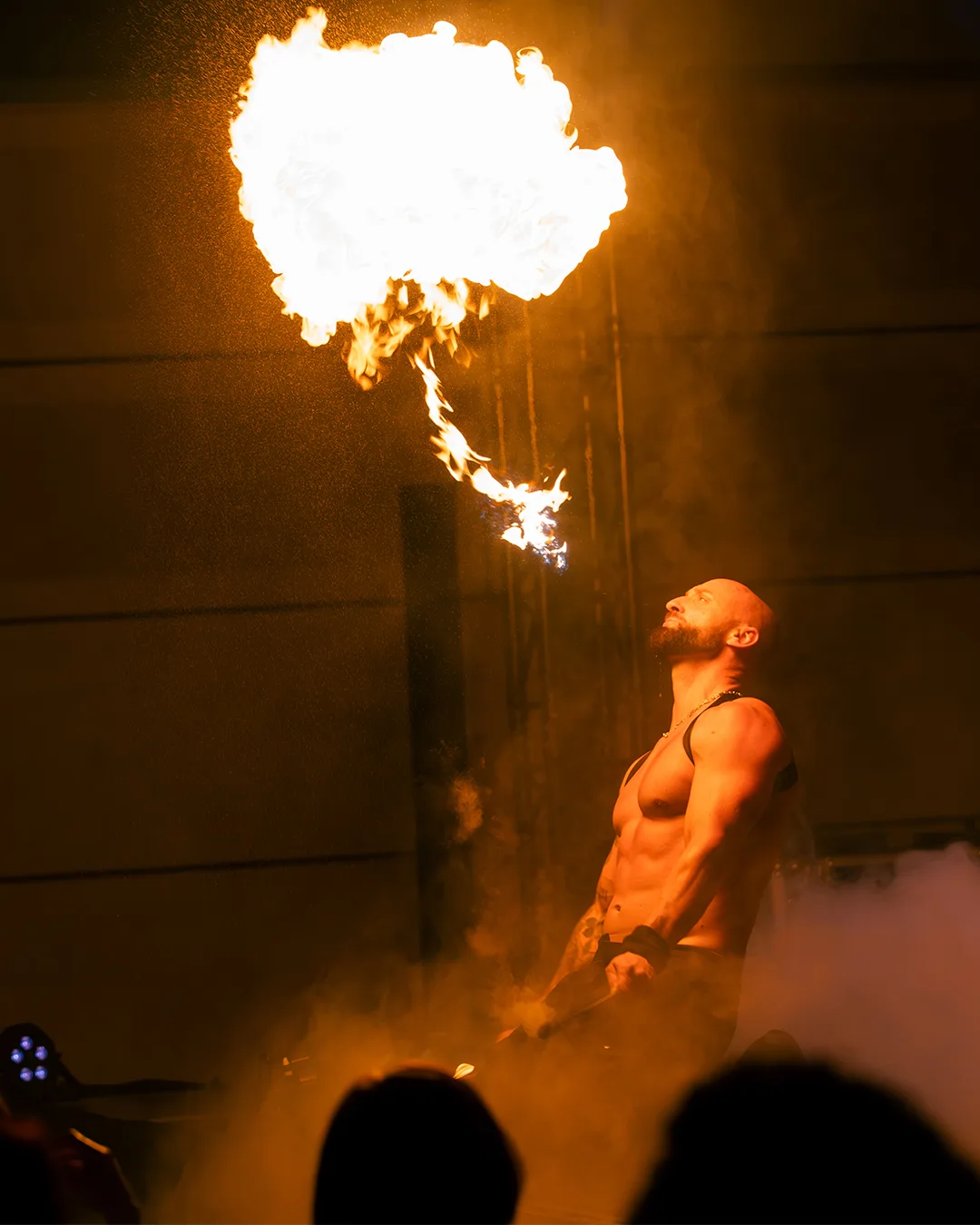 Karl réalisant un numéro de cracheur de feu avec une flamme visible dans les airs