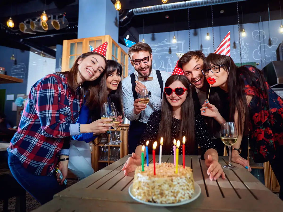 Groupe d'amis réunis autour d'un gâteau d'anniversaire pour une soirée festive